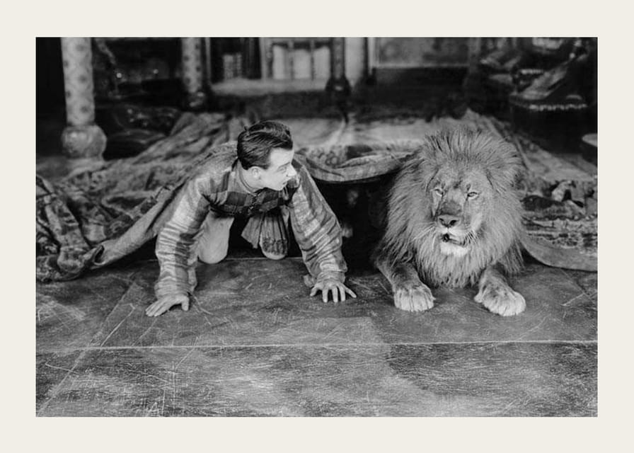 Čiernobiela fotografia mladého muža a leva na podlahe v interiéri-12