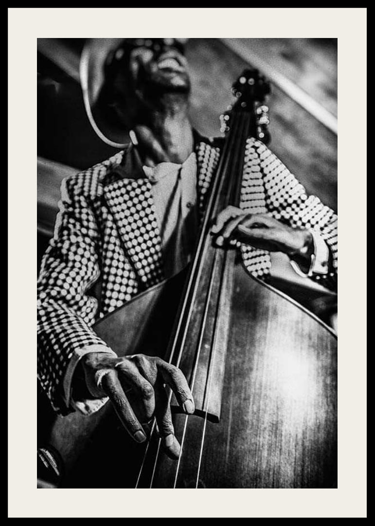 Black and white close-up of man in checkered jacket playing double bass-12