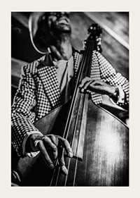 Black and white close-up of man in checkered jacket playing double bass-3