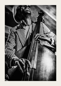 Primo piano in bianco e nero di un uomo con giacca a quadri che suona il contrabbasso-3