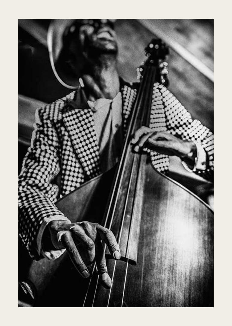 Primo piano in bianco e nero di un uomo con giacca a quadri che suona il contrabbasso-12