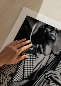 Black and white close-up of man in checkered jacket playing double bass-9