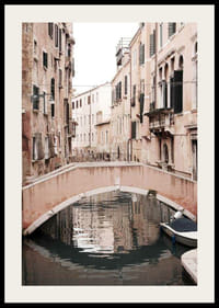 Fotografía de un puente veneciano sobre un canal estrecho, en tonos pastel apagados.-2