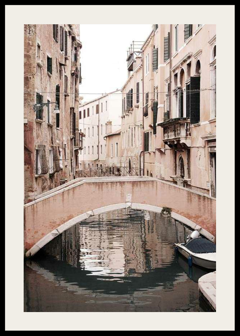 Fotografía de un puente veneciano sobre un canal estrecho, en tonos pastel apagados.-12