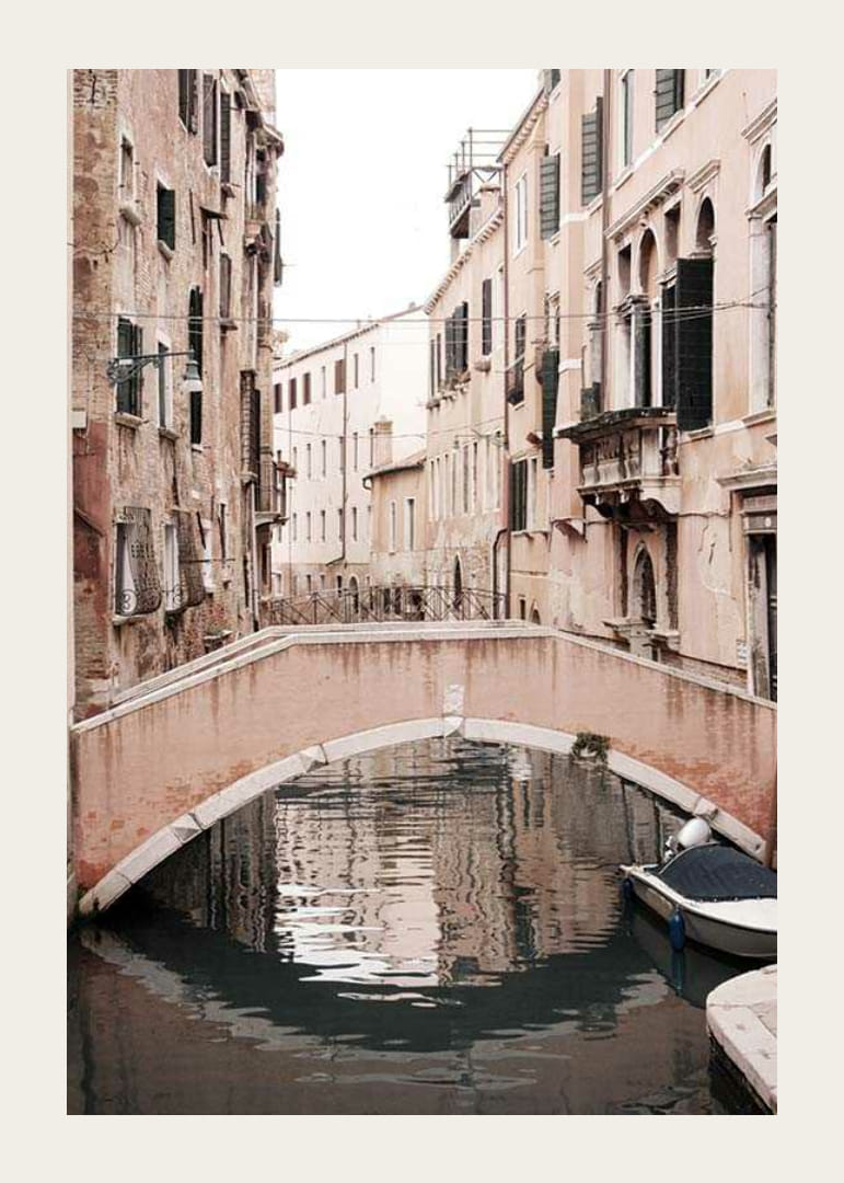 Fotografía de un puente veneciano sobre un canal estrecho, en tonos pastel apagados.-12