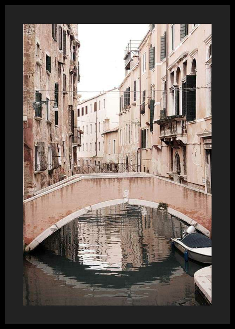 Fotografía de un puente veneciano sobre un canal estrecho, en tonos pastel apagados.-12