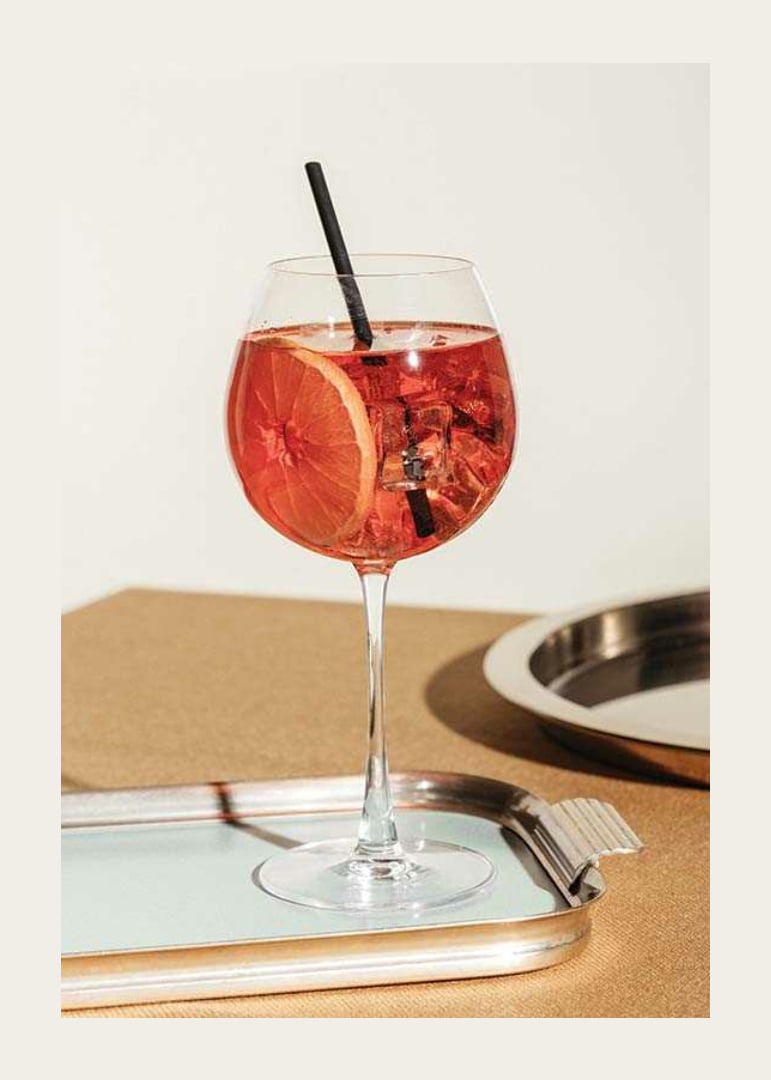 Close-up of Aperol Spritz in wine glass with orange slice-12