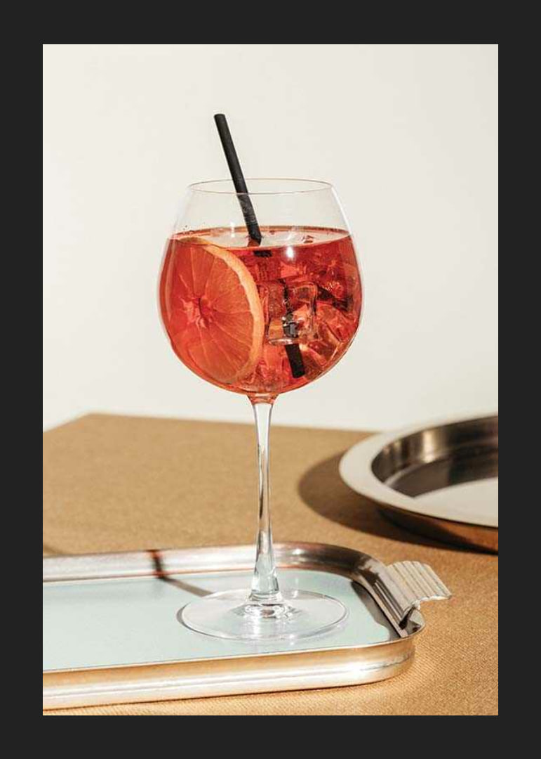 Close-up of Aperol Spritz in wine glass with orange slice-12