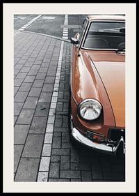 Close-up of orange classic car parked on cobblestones-2