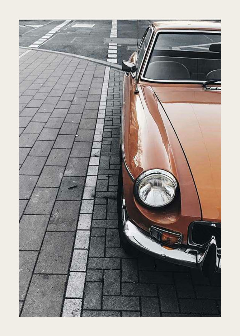 Närbild av orange klassisk bil parkerad på gatsten-12