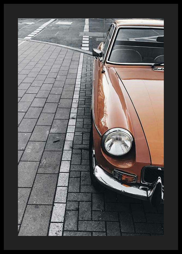 Close-up of orange classic car parked on cobblestones-12