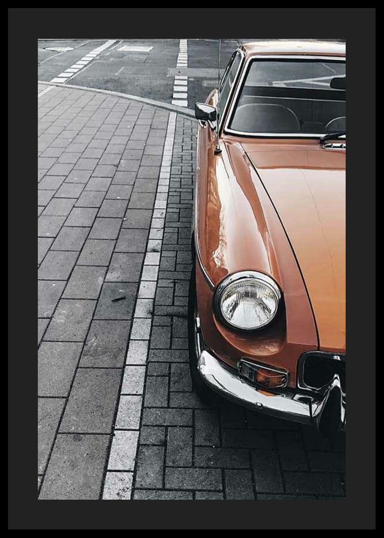 Närbild av orange klassisk bil parkerad på gatsten-12