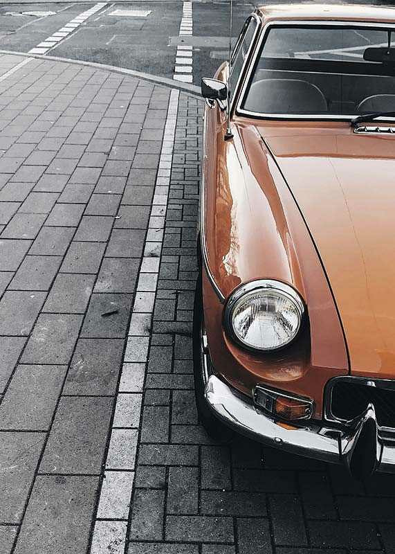 Close-up of orange classic car parked on cobblestones-12