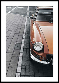 Close-up of orange classic car parked on cobblestones-0