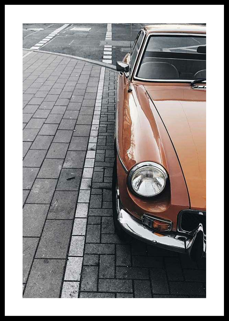 Close-up of orange classic car parked on cobblestones-12
