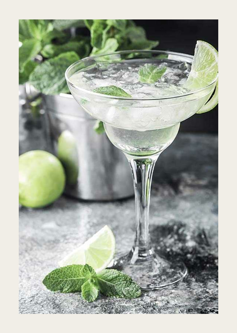 Photograph of margarita in glass with lime and mint leaves-12