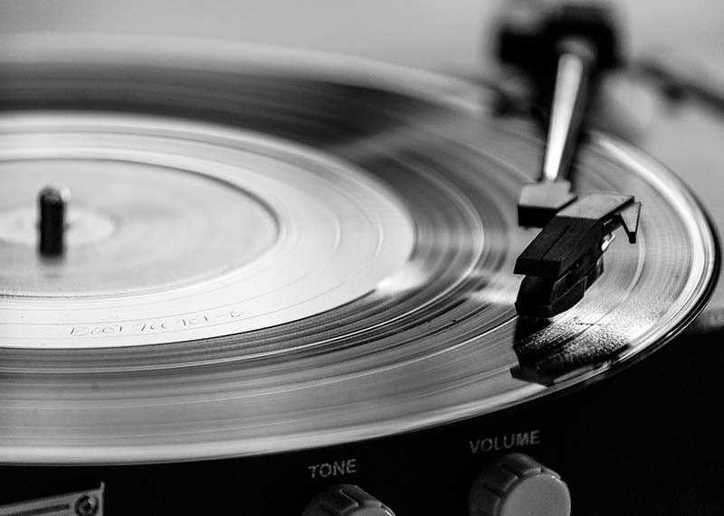 Black and white close-up of vinyl player with vinyl record on it-12