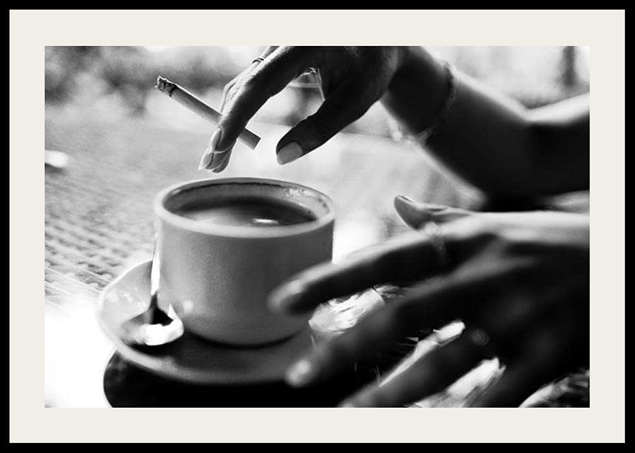 Svartvitt foto av hand med cigarett över kaffekopp-12
