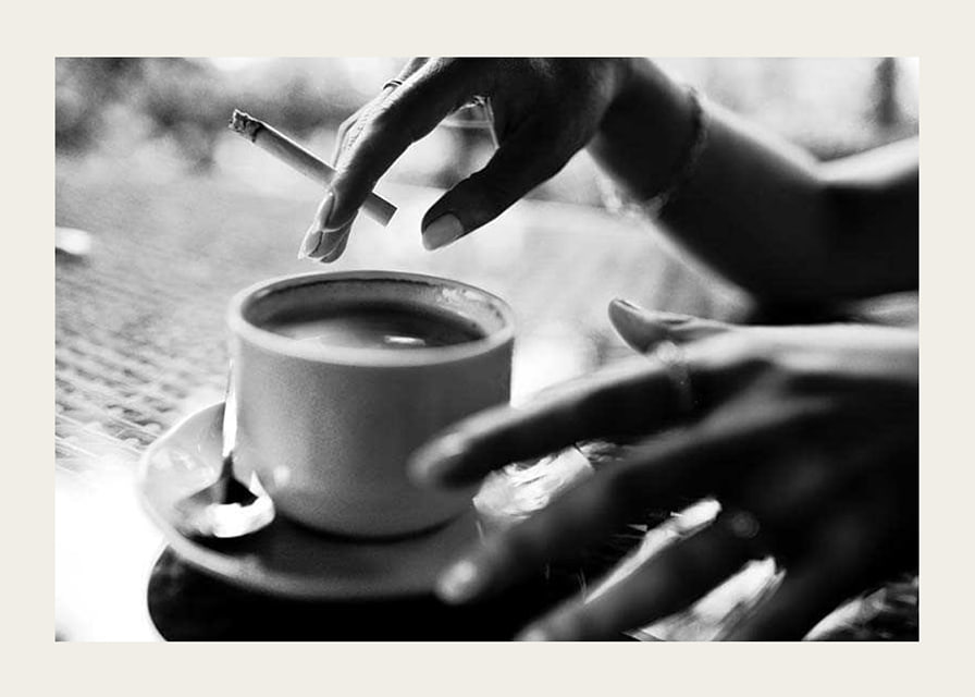 Svartvitt foto av hand med cigarett över kaffekopp-12