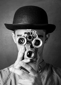 Black and white close-up of young man with hat and antique film camera-7