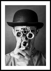 Black and white close-up of young man with hat and antique film camera-0
