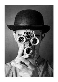 Black and white close-up of young man with hat and antique film camera-1