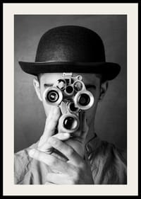 Primer plano en blanco y negro de un joven con sombrero y una cámara de película antigua-2