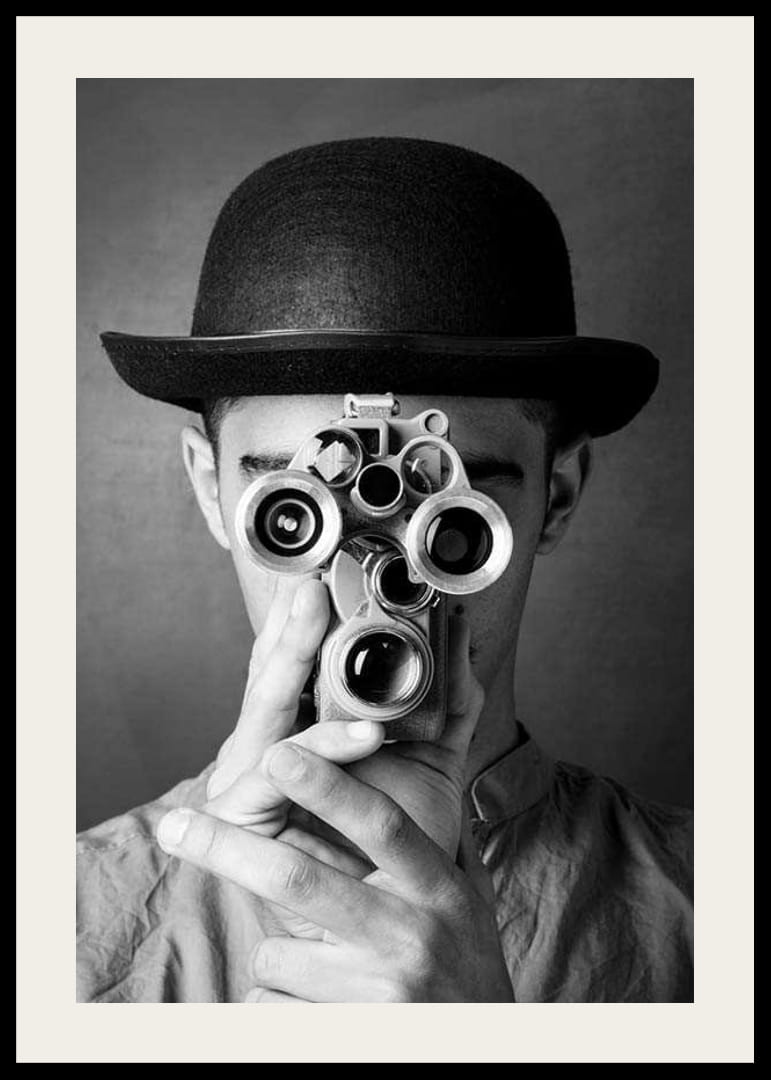 Primer plano en blanco y negro de un joven con sombrero y una cámara de película antigua-12