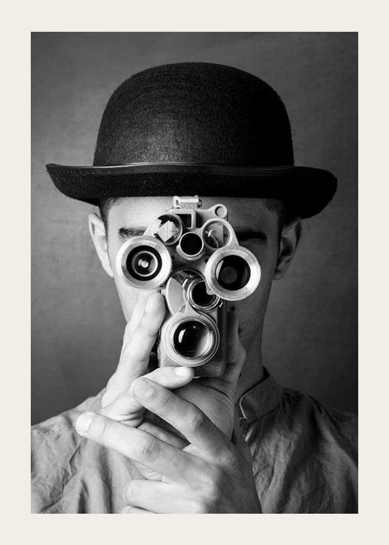 Black and white close-up of young man with hat and antique film camera-12
