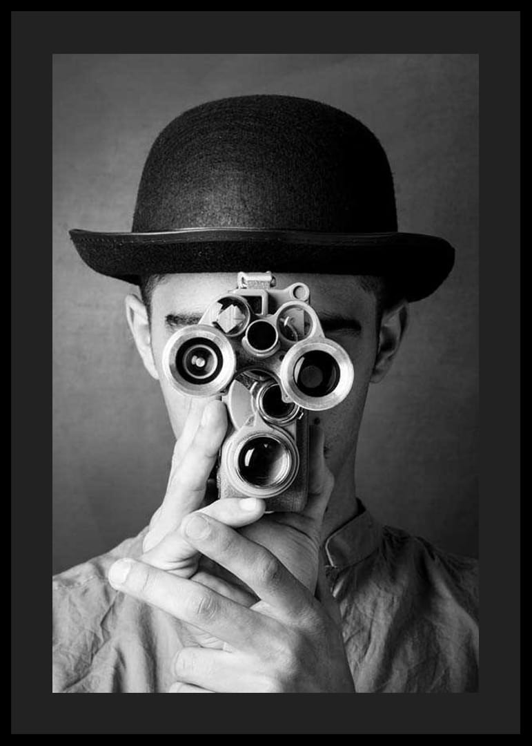 Primer plano en blanco y negro de un joven con sombrero y una cámara de película antigua-12