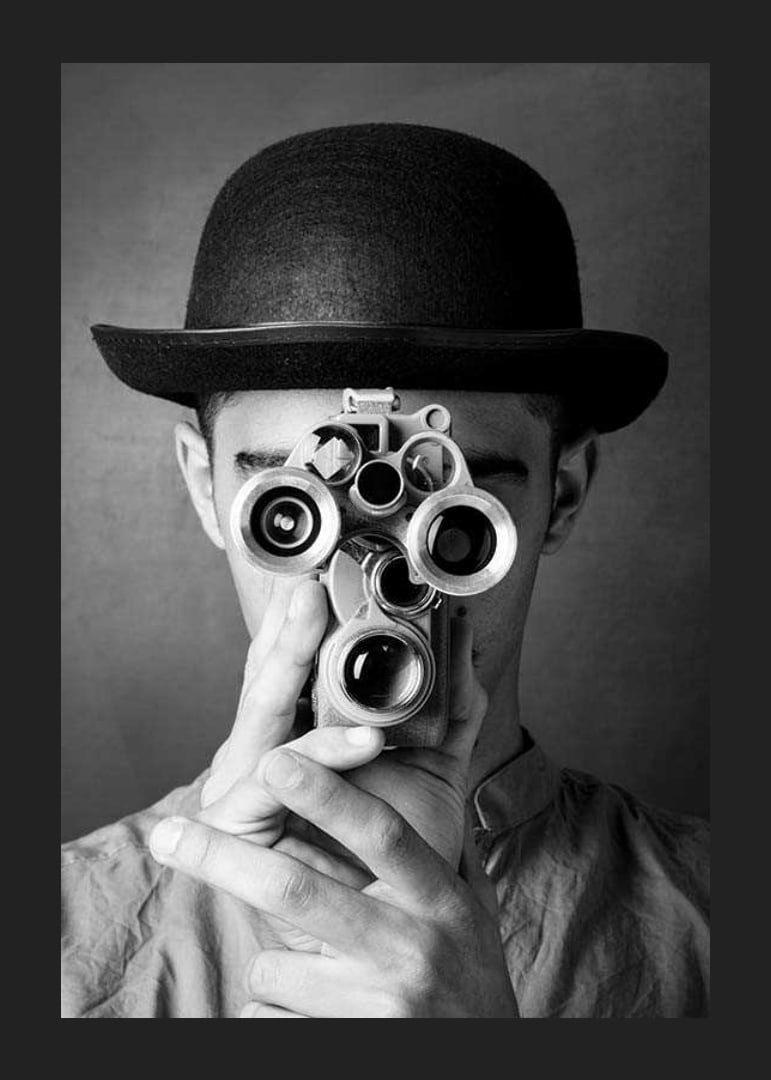 Black and white close-up of young man with hat and antique film camera-12