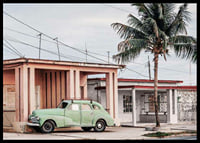Fotografi av grön vintagebil framför pastellfärgat hus och palm-6