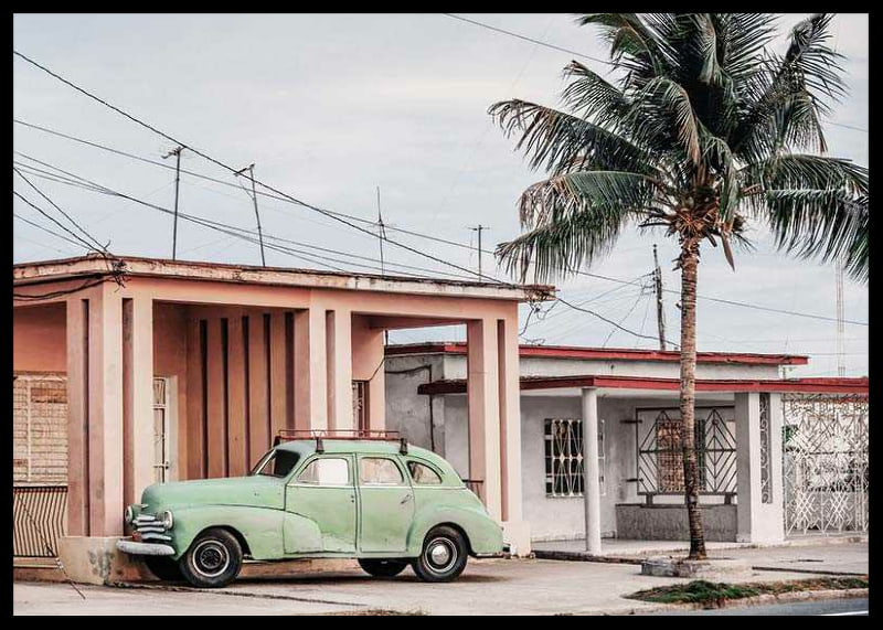 Fotografi av grön vintagebil framför pastellfärgat hus och palm-12