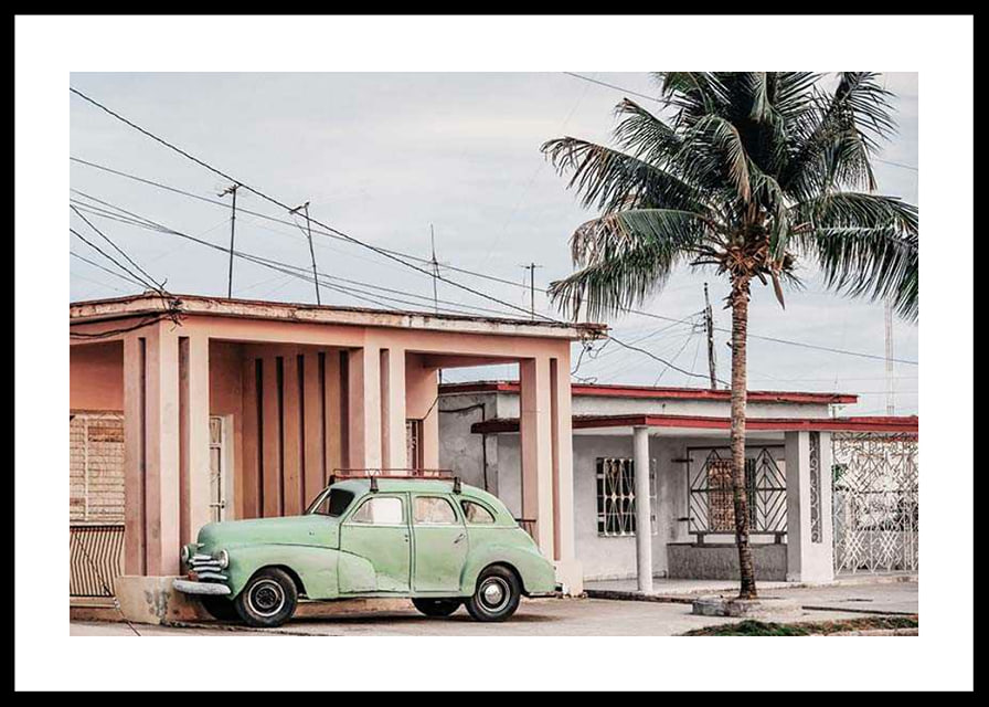 Fotografi av grön vintagebil framför pastellfärgat hus och palm-12