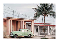 Fotografi av grön vintagebil framför pastellfärgat hus och palm-1