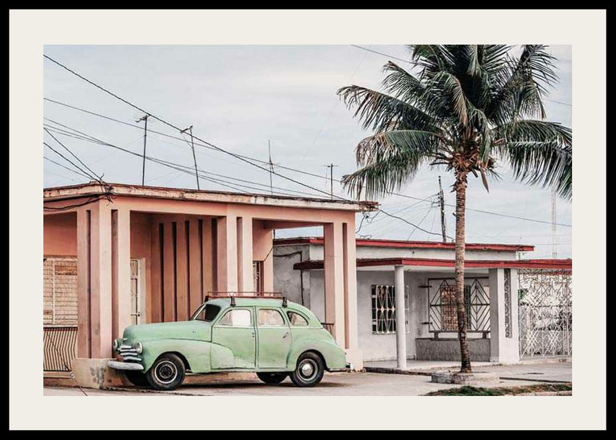 Photographie d'une voiture verte vintage devant une maison aux couleurs pastel et un palmier-12