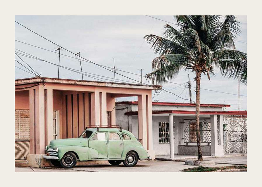 Photographie d'une voiture verte vintage devant une maison aux couleurs pastel et un palmier-12