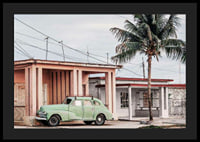 Fotografi av grön vintagebil framför pastellfärgat hus och palm-4