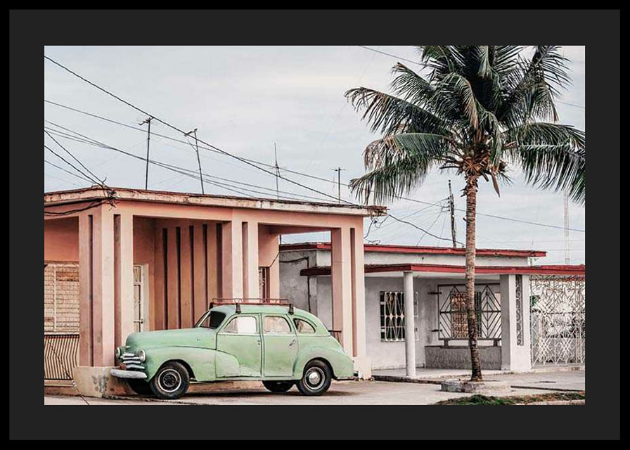 Fotografi av grön vintagebil framför pastellfärgat hus och palm-12