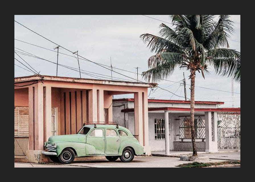 Photographie d'une voiture verte vintage devant une maison aux couleurs pastel et un palmier-12