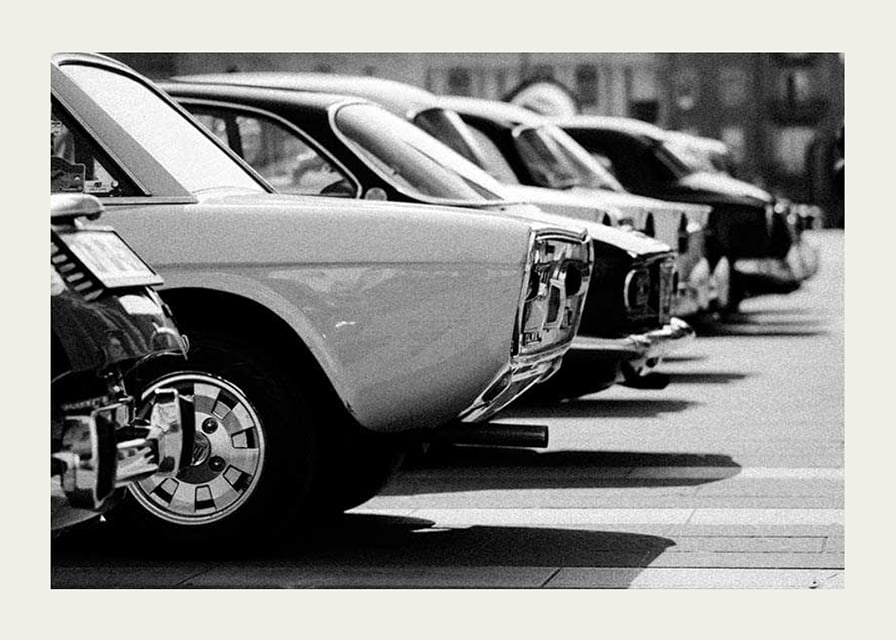 Black and white photography of classic cars in a row in a parking lot-12