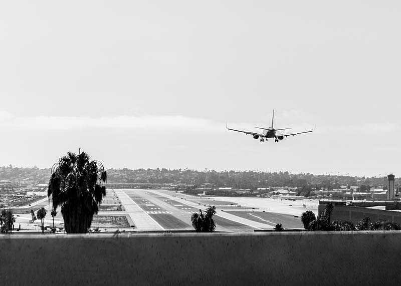 Svartvitt fotografi av flygplan som landar på lång landningsbana-12