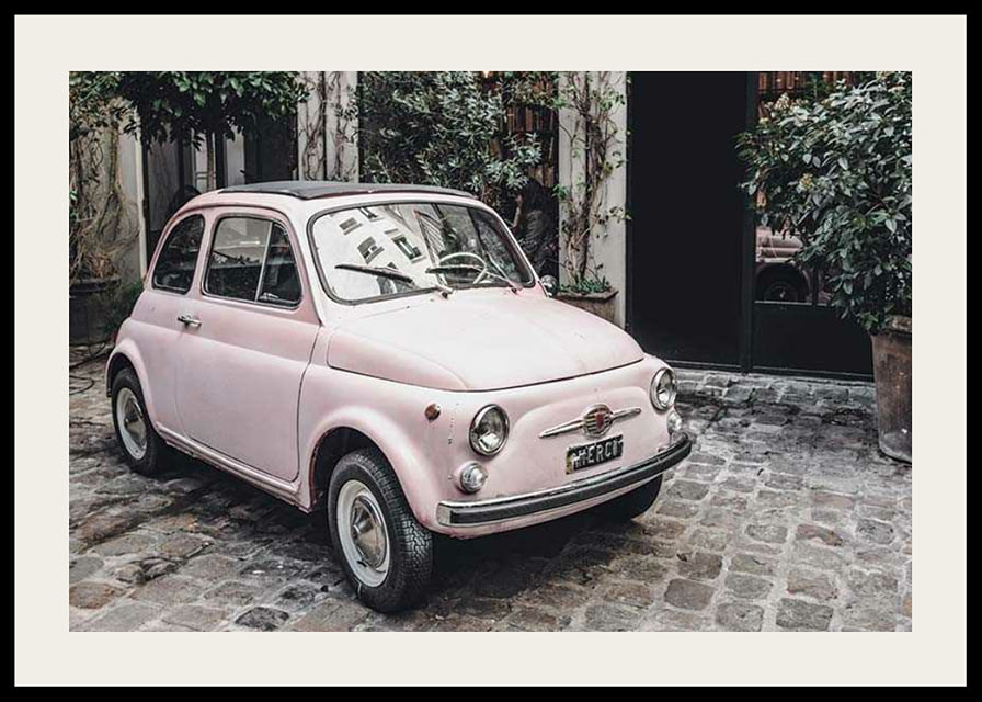 Vintage rosa bil parkerad på kullerstensgata utomhus-12