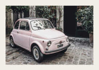 Vintage ružové auto zaparkované na dláždenej ulici vonku-3