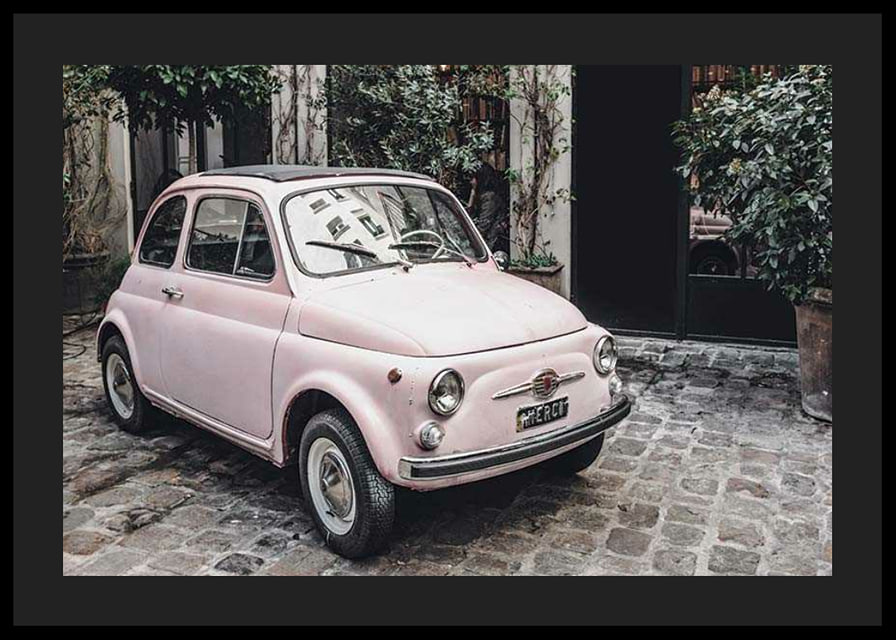 Vintage rosa bil parkerad på kullerstensgata utomhus-12