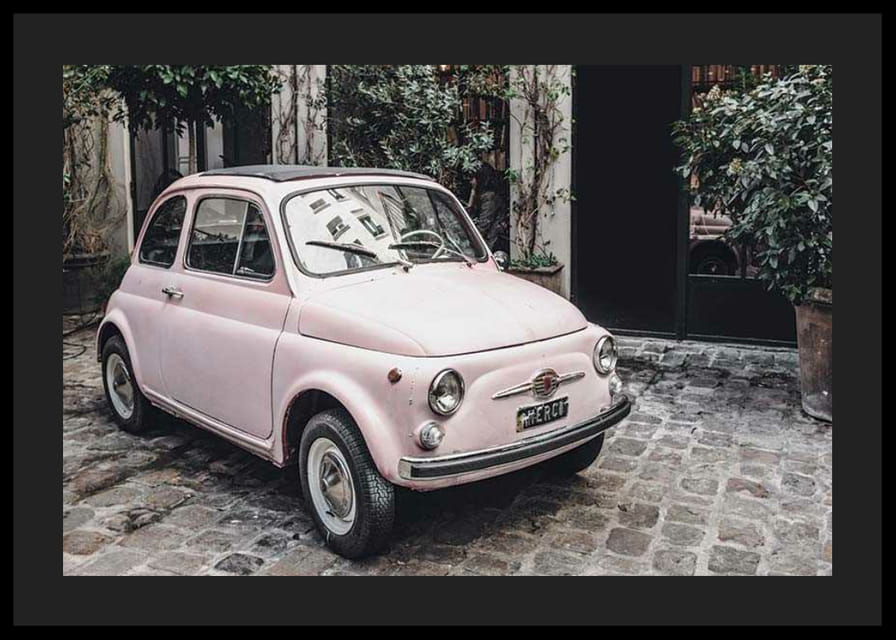 Vintage ružové auto zaparkované na dláždenej ulici vonku-12