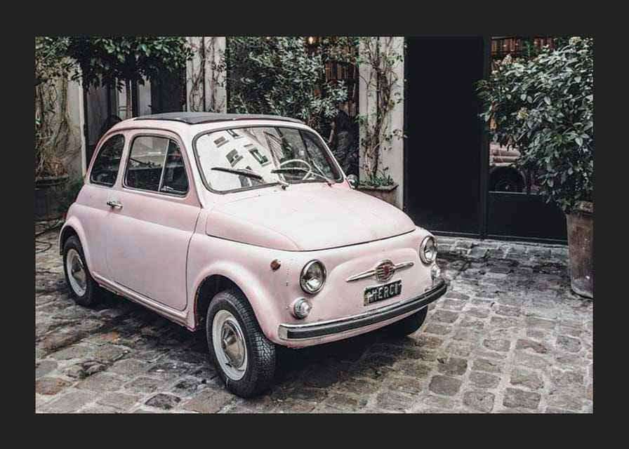 Vintage ružové auto zaparkované na dláždenej ulici vonku-12