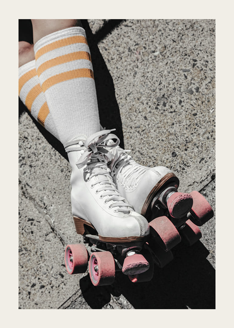 Fotografía de patines blancos con ruedas rosas sobre asfalto.-12