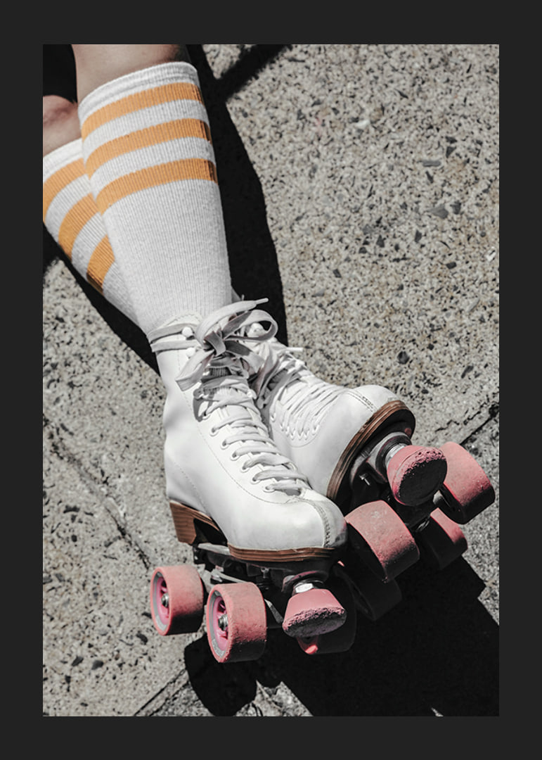 Photograph of white roller skates with pink wheels on asphalt-12
