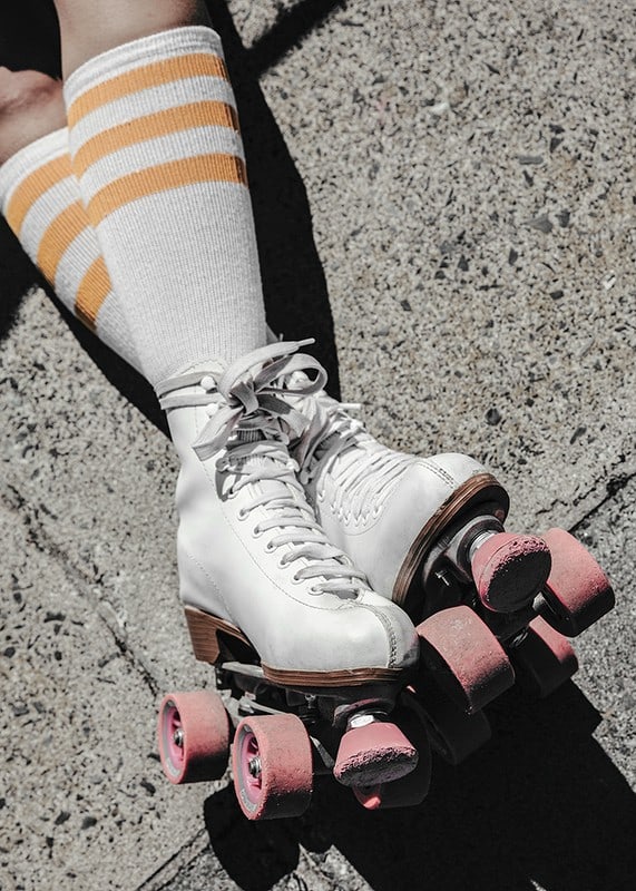 Photograph of white roller skates with pink wheels on asphalt-12